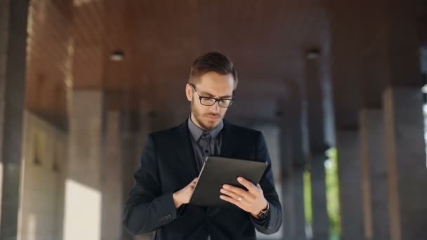 Joven hombre de negocios barbudo escribiendo correo electrónico de negocios utilizando su PC tableta — Vídeos de Stock