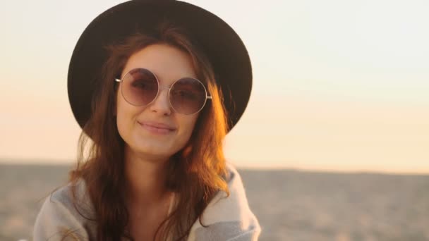 Retrato de una hermosa joven en la playa al atardecer — Vídeos de Stock