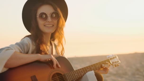 Piękna młoda kobieta gra na gitarze na plaży — Wideo stockowe