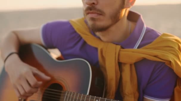 Ağır çekim. genç çocuk gitar günbatımında çalıyor. — Stok video