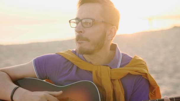 Lento movimento. jovem rapaz toca guitarra ao pôr do sol — Vídeo de Stock