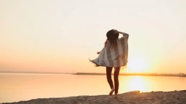 ağır çekim. kaygısız kadın günbatımında kumsalda dans