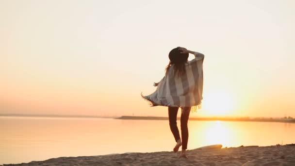 Zeitlupe. Unbekümmerte Frau tanzt im Sonnenuntergang am Strand — Stockvideo