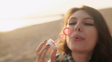 Kız sahilde kabarcıklar üfleme