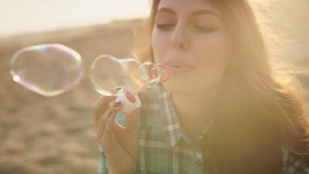 Meisje blaast bellen op het strand — Stockvideo