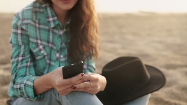 Ung snygg pretty woman, händer som håller en telefon, jeansskjorta och jeans — Stockvideo