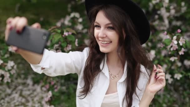 Mulher feliz tomando selfie no tablet no jardim florescendo . — Vídeo de Stock