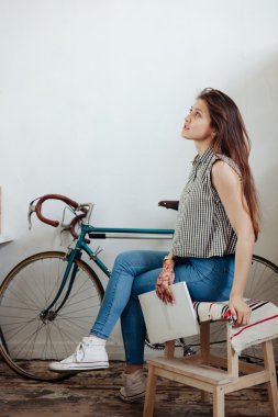 Genç kadın kahve veya çay ve okuma dergi yudumlarken