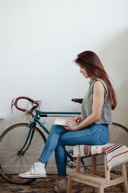 Genç kadın kahve veya çay ve okuma dergi yudumlarken