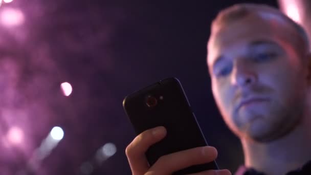 Mann benutzt Smartphone, Bild von Feuerwerk als Hintergrund. — Stockvideo