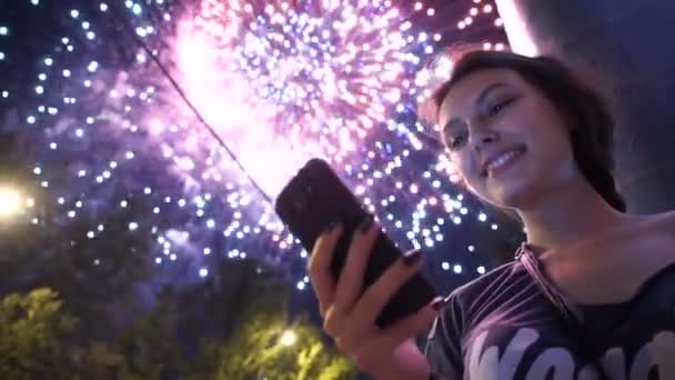 Meisje gebruik slimme telefoon, afbeelding van vuurwerk als achtergrond. — Stockvideo