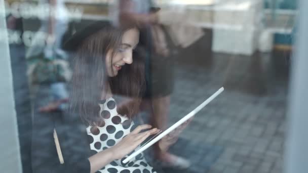 Mujer joven usando la tableta en la cafetería — Vídeos de Stock