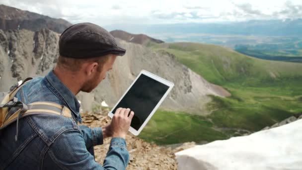 Mans handen aanraken scherm voor digitale tablet op de achtergrond van bergen — Stockvideo