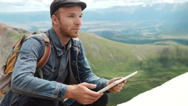 Mans kezében megható képernyő, digitális tabletta, a háttérben a hegyek — Stock videók