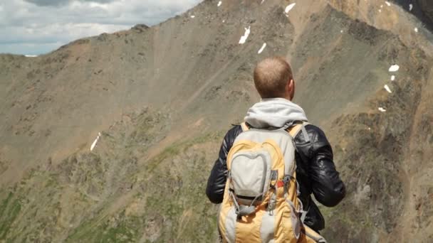 Πεζοπόρος με σακίδιο στέκεται στην κορυφή ενός βουνού — Αρχείο Βίντεο