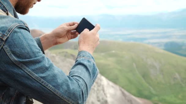 强壮的男人的徒步旅行者拍照智能手机在山的顶峰。奇妙的黎明. — 图库视频影像