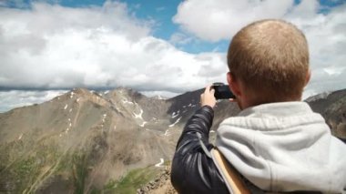 Turist akıllı telefon ile fotoğraf kaya tepe üzerinde alır.
