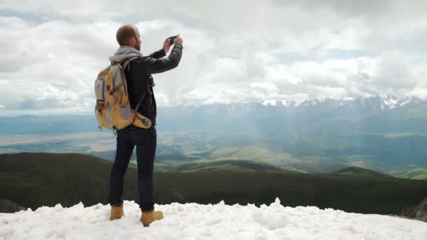 Ισχυρός άνδρας πεζοπόρος λήψη φωτογραφιών με έξυπνο τηλέφωνο στην κορυφή του βουνού. Θαυμάσια Χαραυγή. — Αρχείο Βίντεο