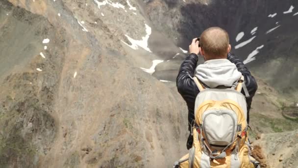 Turista tira fotos com telefone inteligente no pico do rock — Vídeo de Stock