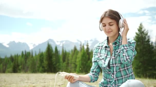 Beautiful Young Woman with Headphones Outdoors. Enjoying Music. — Stock Video