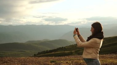 kadın uzun yürüyüşe çıkan kimse alarak fotoğraf ile dağ tepe cliff, akıllı telefon