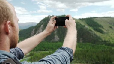 Akıllı telefon kullanan adam bir fotoğraf dağ görüş almak