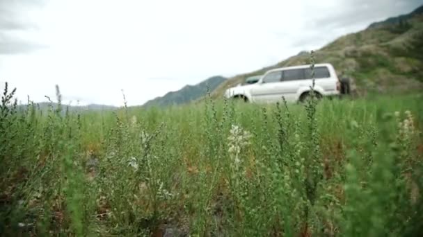 Rueda de coche grande está de pie sobre las rocas en el telón de fondo de montaña. Montañas Altay, Siberia, Rusia — Vídeo de stock