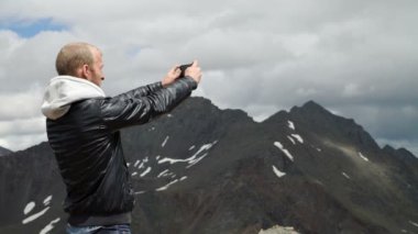 Turist akıllı telefon ile fotoğraf kaya tepe üzerinde alır.