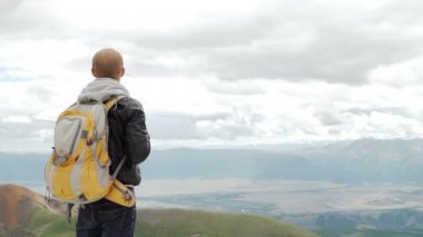 Bulutların üstünde yüksek irtifa dağ görünümünde bakarak uzun yürüyüşe çıkan kimse.