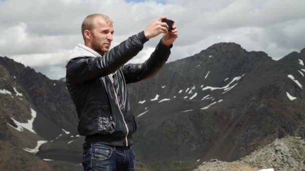 Güçlü adam uzun yürüyüşe çıkan kimse alarak fotoğraf dağ tepe, akıllı telefon ile. Muhteşem daybreak. — Stok video