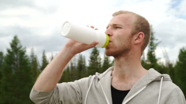 Hiker drycker klart vatten på toppen av bergen — Stockvideo