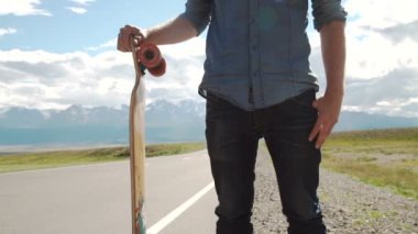 Spor, boş zaman, insanlar ve genç adam ya da dağ yolda longboard ile genç gülümseyen genç kavramı-.