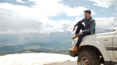 Mutlu Traveler adam arabasını dağlar üstüne oturan. 4 x 4 trekking seyahat
