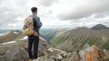 bir kayanın üstünde seyahat etmek sırt çantası ile adam