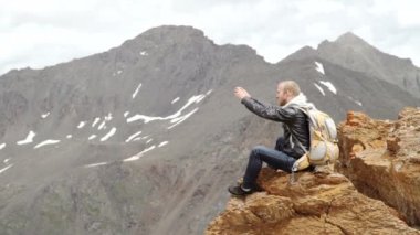 Güçlü adam uzun yürüyüşe çıkan kimse alarak fotoğraf dağ tepe, akıllı telefon ile. Muhteşem daybreak.