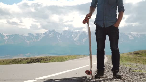 Tetovált férfi egy piros póló, pózol a longboard, szakállas. — Stock videók