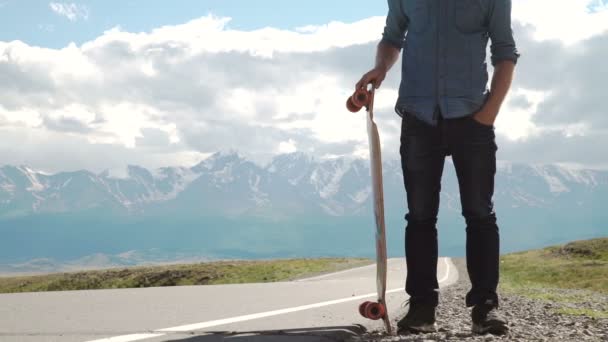 Deporte, ocio, personas y concepto adolescente - sonriente joven o adolescente con longboard en carretera de montaña . — Vídeos de Stock