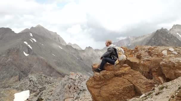 Junger Reisender entspannt in den Bergen — Stockvideo