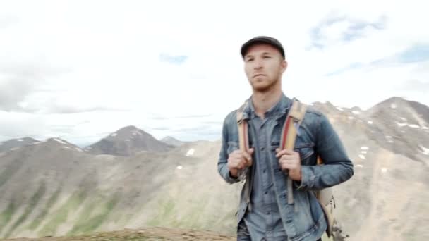 Outdoor portrait of Young man hiking on the mountains, smiling happy portrait of tourist male.extreme sport — стоковое видео