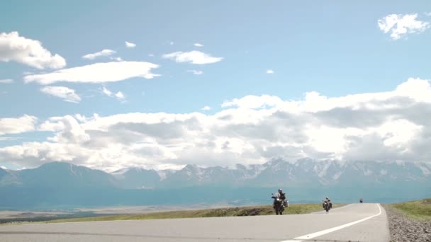 En man rider motorcykel ner en bergsväg circa — Stockvideo