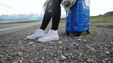 Güneşli bir yolda otostop ve yürüyüş Gezgin kadın. Bir güneşli ülke yolda bir yolculuğa başlamak için kadın genç mutlu backpacker bir sürüş için arıyorum. Ağır çekim
