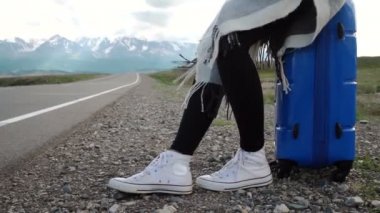 Güneşli bir yolda otostop ve yürüyüş Gezgin kadın. Bir güneşli ülke yolda bir yolculuğa başlamak için kadın genç mutlu backpacker bir sürüş için arıyorum. Ağır çekim