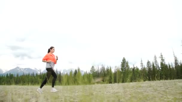 Молодая спортсменка бегает по горной тропе. Следите за камерой. Закат тренировки в природе. Slow Motion — стоковое видео