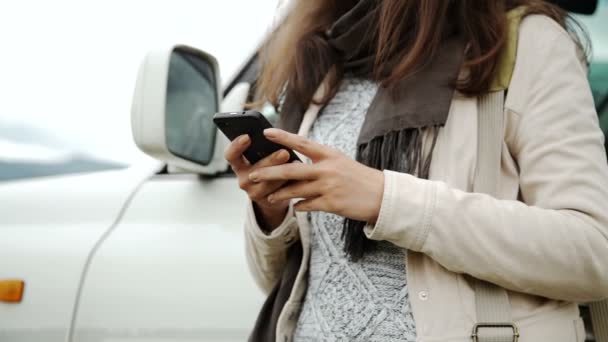 Mujer que utiliza la navegación GPS en el teléfono inteligente cerca del coche en la carretera — Vídeo de stock