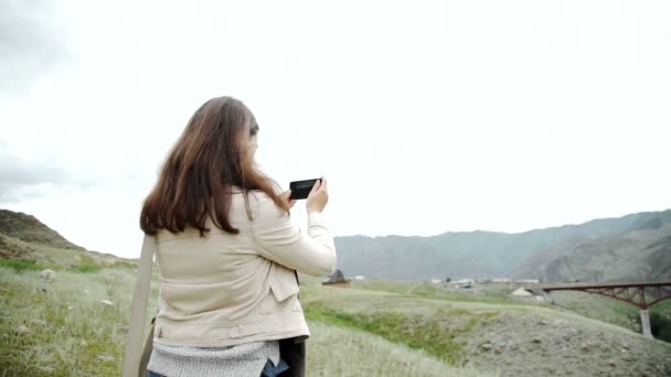 Dağlarda yürüyüş ve cep telefonu ile fotoğraf çekme üzerine gencin rahatlatır — Stok video