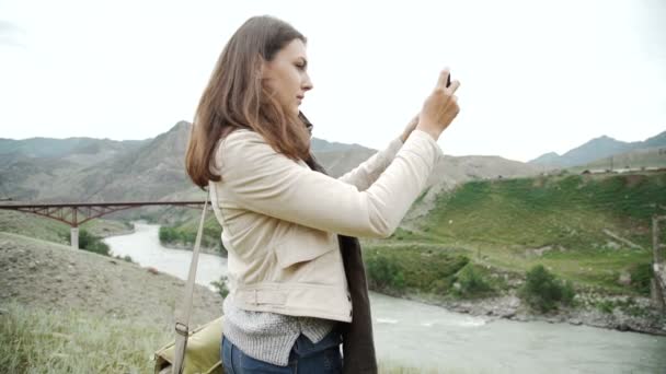Dağlarda yürüyüş ve cep telefonu ile fotoğraf çekme üzerine gencin rahatlatır — Stok video