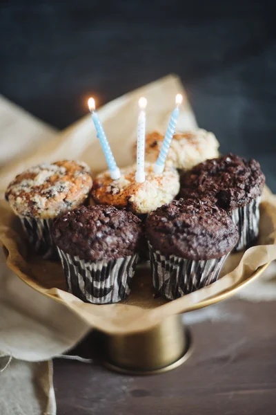 Muffin al cioccolato di compleanno con tre candele su sfondo nero — Foto Stock