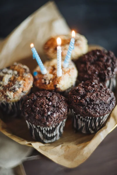 Kue ulang tahun coklat muffin dengan tiga lilin dengan latar belakang hitam — Stok Foto