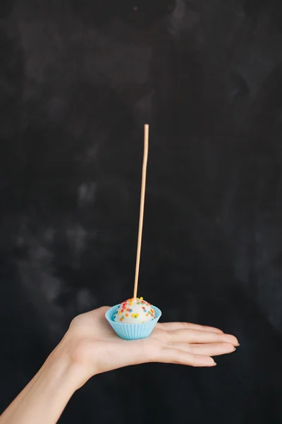 Hand holding lollipop isolated on black background — Stock Photo, Image