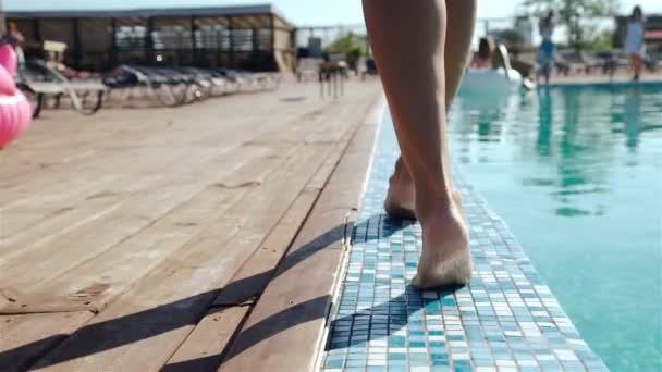 Feche em umas pernas de mulher enquanto caminha ao lado de uma piscina, 20s. Movimento lento de 1080p — Vídeo de Stock